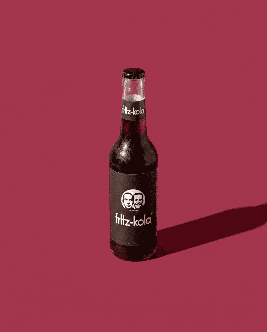 Fritz Kola Candela Rolls Studio 4 Botella de Fritz-Kola en fondo rosa con sombra.