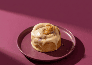 Dulce de leche y galleta en un postre en plato rosa.